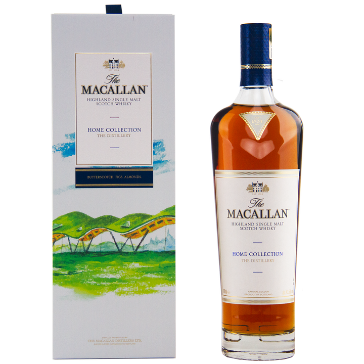 A bottle of The Macallan Home Collection The Distillery Single Malt Scotch Whisky sits beside its decorative box, adorned with green hills and an arched distillery illustration—a must-have collectible for whisky enthusiasts.