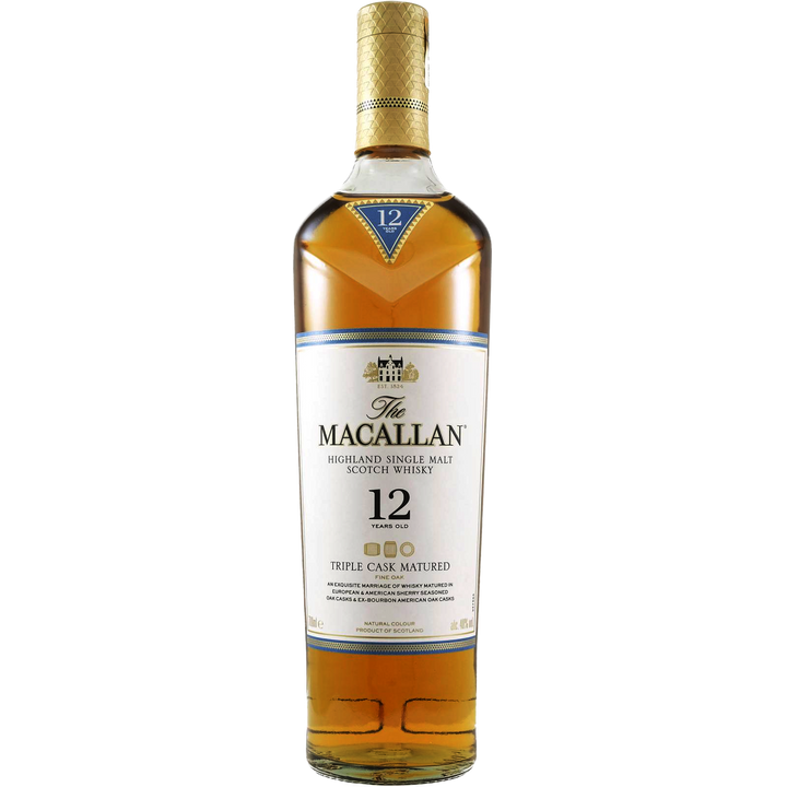 A bottle of The Macallan Triple Cask 12 Year Old Single Malt Scotch Whisky, featuring a gold and white label with a blue neck label and triple cask maturation details, is displayed against a plain white background.