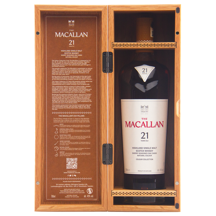 A bottle from The Macallan Colour Collection Set, a 21-year-old single malt Scotch whisky, is displayed in an open wooden box featuring branded details and sherry-seasoned oak maturation info inside the lid.