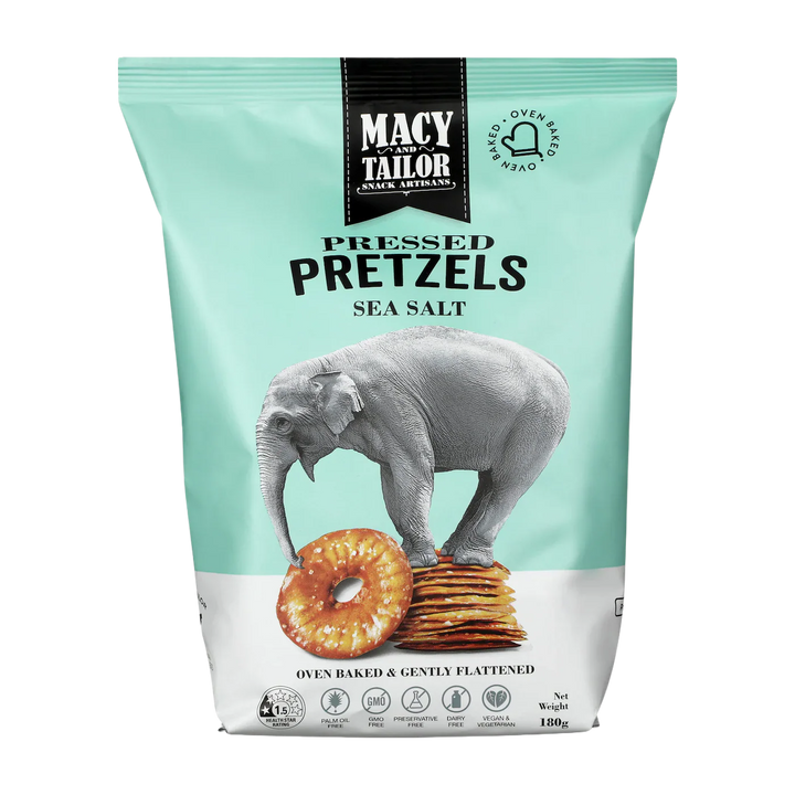 A light blue and white bag of Macy and Tailor Pressed Pretzels Sea Salt, made with natural ingredients, features an elephant standing on pretzels and displays product details and icons at the bottom.