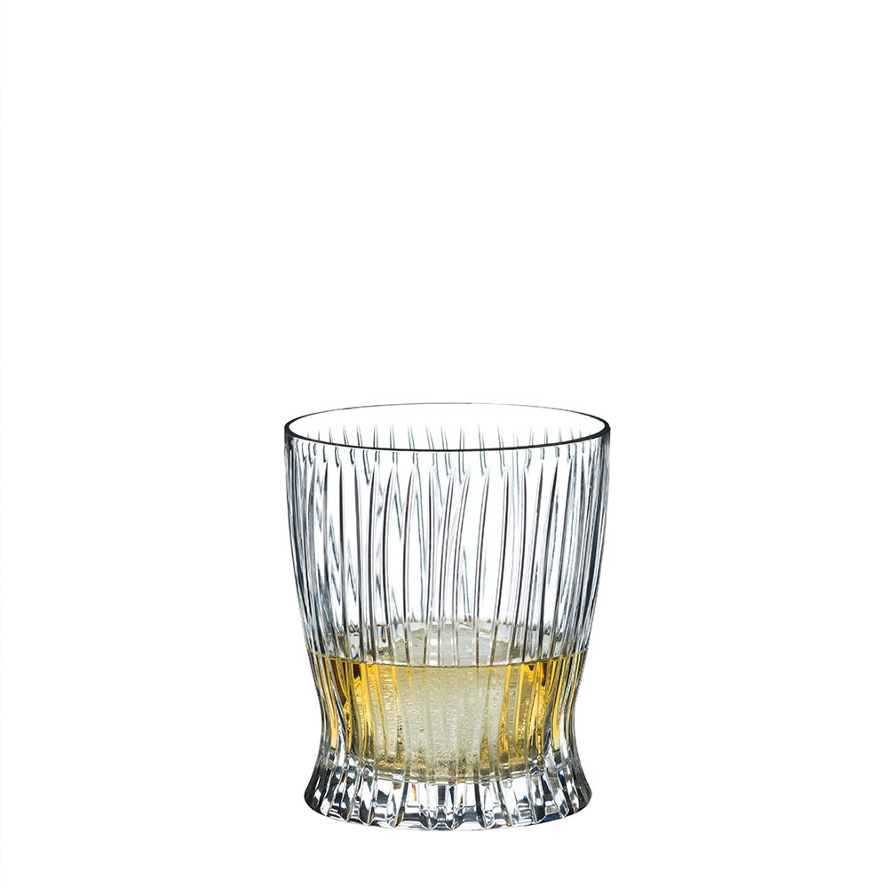 The RIEDEL Fire Whisky Tumbler Collection features clear, textured tumblers with vertical grooves, perfect for enjoying fine whiskies. Shown partially filled with a light amber liquid against a plain white background.