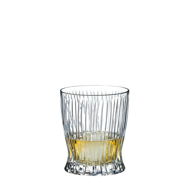 The RIEDEL Fire Whisky Tumbler Collection features clear, textured tumblers with vertical grooves, perfect for enjoying fine whiskies. Shown partially filled with a light amber liquid against a plain white background.