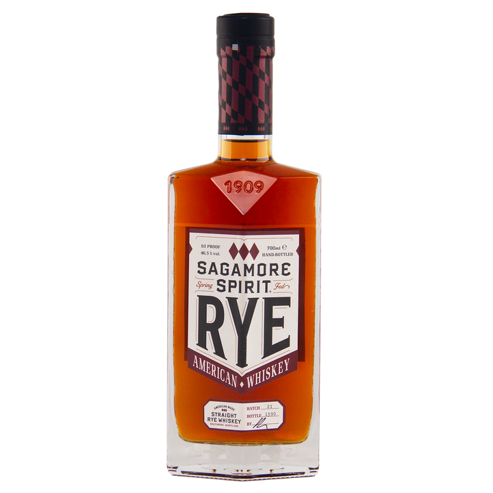 A bottle of Sagamore Small Batch Straight Rye American Whiskey features amber liquid, a maroon and black-checkered cap, and a white label displaying the brand name and whiskey details.