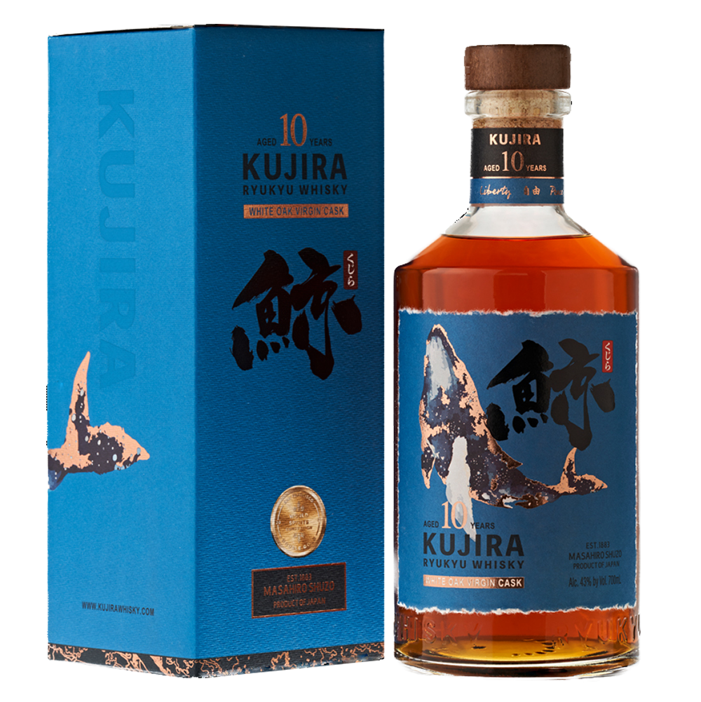A bottle of Kujira Ryukyu 10 Year Old Japanese Whisky stands next to its blue box, both decorated with Japanese calligraphy and a whale illustration. The amber single grain whisky is finished in white oak virgin casks.