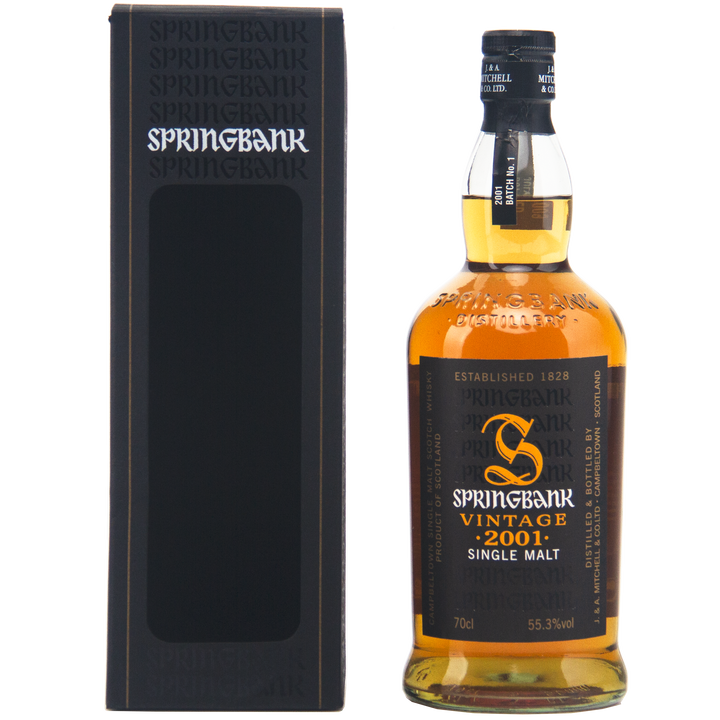 A bottle of alcohol beside a box with Springbank Vintage 2001 Single Malt Scotch Whisky in the background, featuring hints of cask strength single malt Scotch.