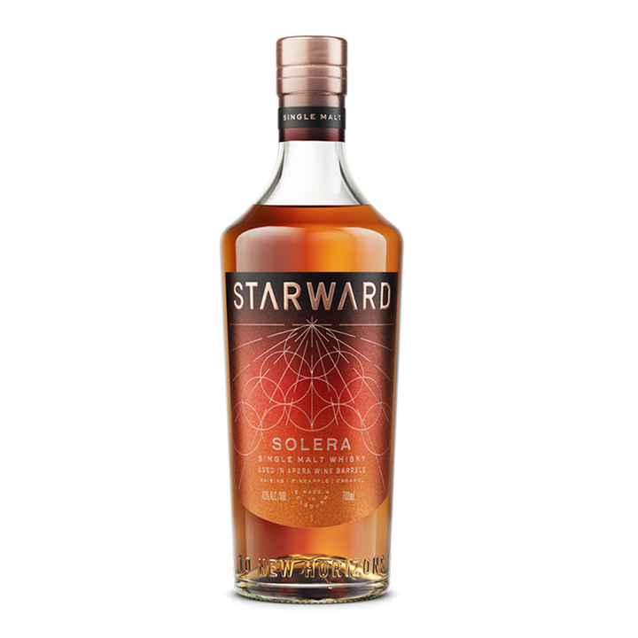 A bottle of Starward Solera Australian Single Malt Whisky with a copper cap and a dark red and gold geometric label highlighting its unique maturation in Apera barrels.