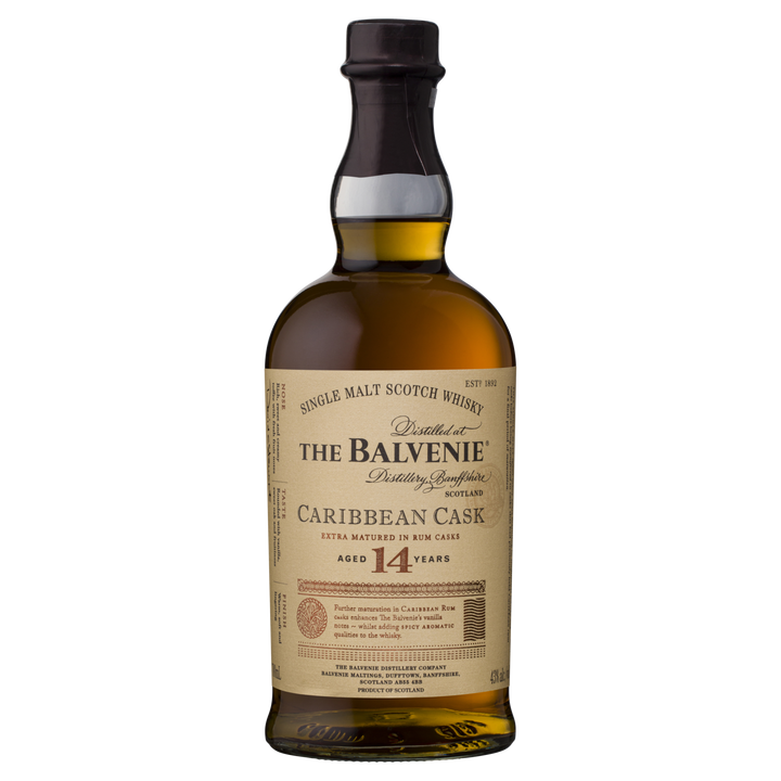A bottle of The Balvenie Caribbean Cask 14 Year Old Single Malt Scotch Whisky, finished in rum casks, with a cream label featuring gold and black text highlighting its unique Speyside aging process.