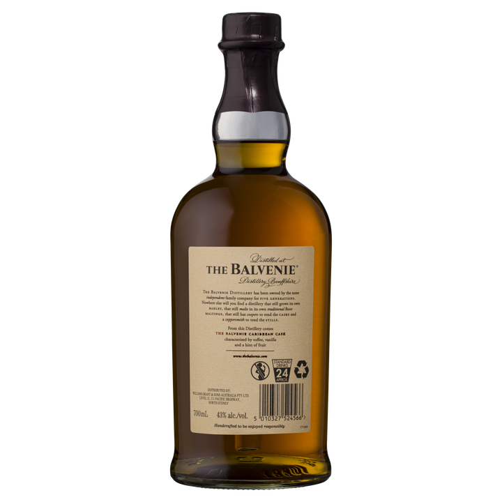 The Balvenie Caribbean Cask 14 Year Old Single Malt Scotch Whisky is shown from the back, highlighting its beige product details label. The amber Speyside whisky is visible inside, sealed with a dark cap.