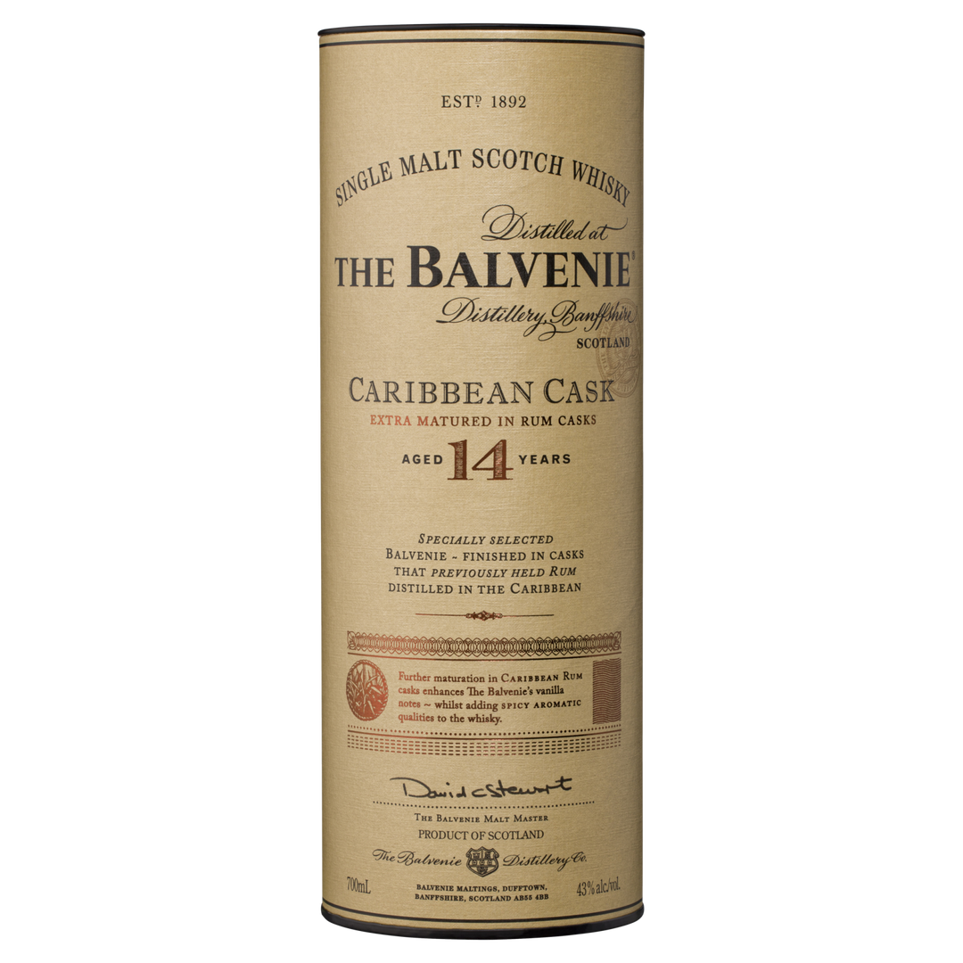 Cylindrical container of The Balvenie Caribbean Cask 14 Year Old Single Malt Scotch Whisky. The beige label displays black and gold text with product details and a signature at the bottom.