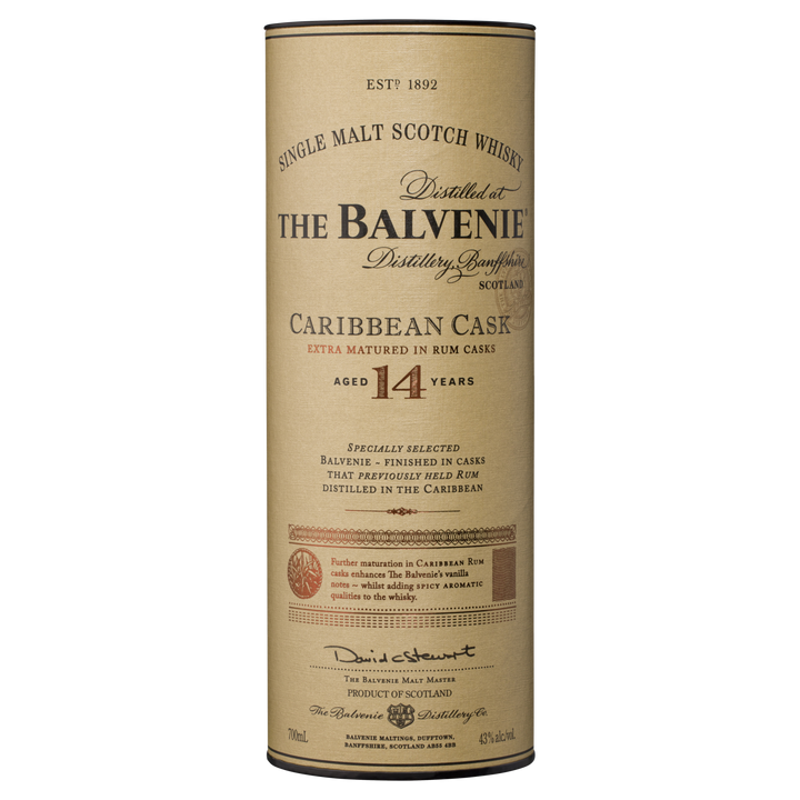 Cylindrical container of The Balvenie Caribbean Cask 14 Year Old Single Malt Scotch Whisky. The beige label displays black and gold text with product details and a signature at the bottom.