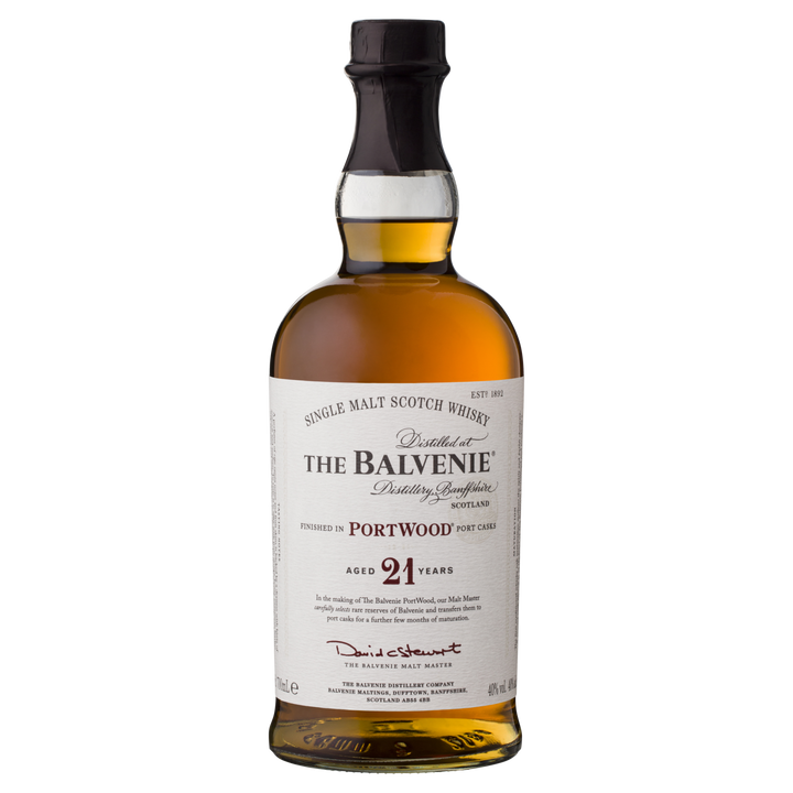 A bottle of The Balvenie PortWood 21 Year Old Single Malt Scotch Whisky features a dark neck, clear glass with amber liquid, and a label highlighting port cask finishing, distillery details, and signature.