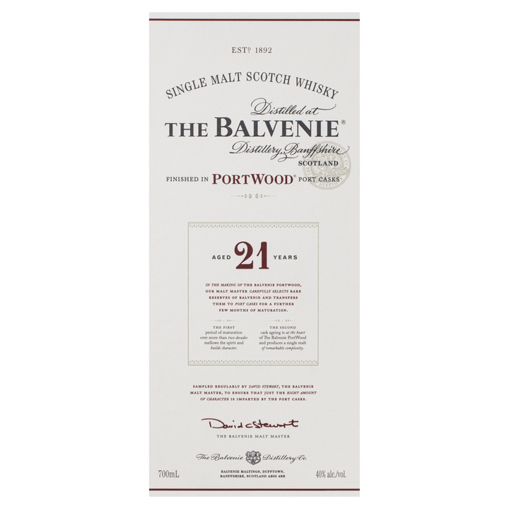 The Balvenie PortWood 21 Year Old Single Malt Scotch Whisky's label features details on its 21-year aging, port cask finishing, Scottish distillery location, a signature, and comes in white packaging with gold and red accents.