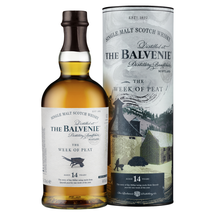A bottle of The Balvenie Stories The Week of Peat 14 Year Old Single Malt Scotch Whisky is displayed in front of its cylindrical packaging, which features distillery-themed imagery and branding.