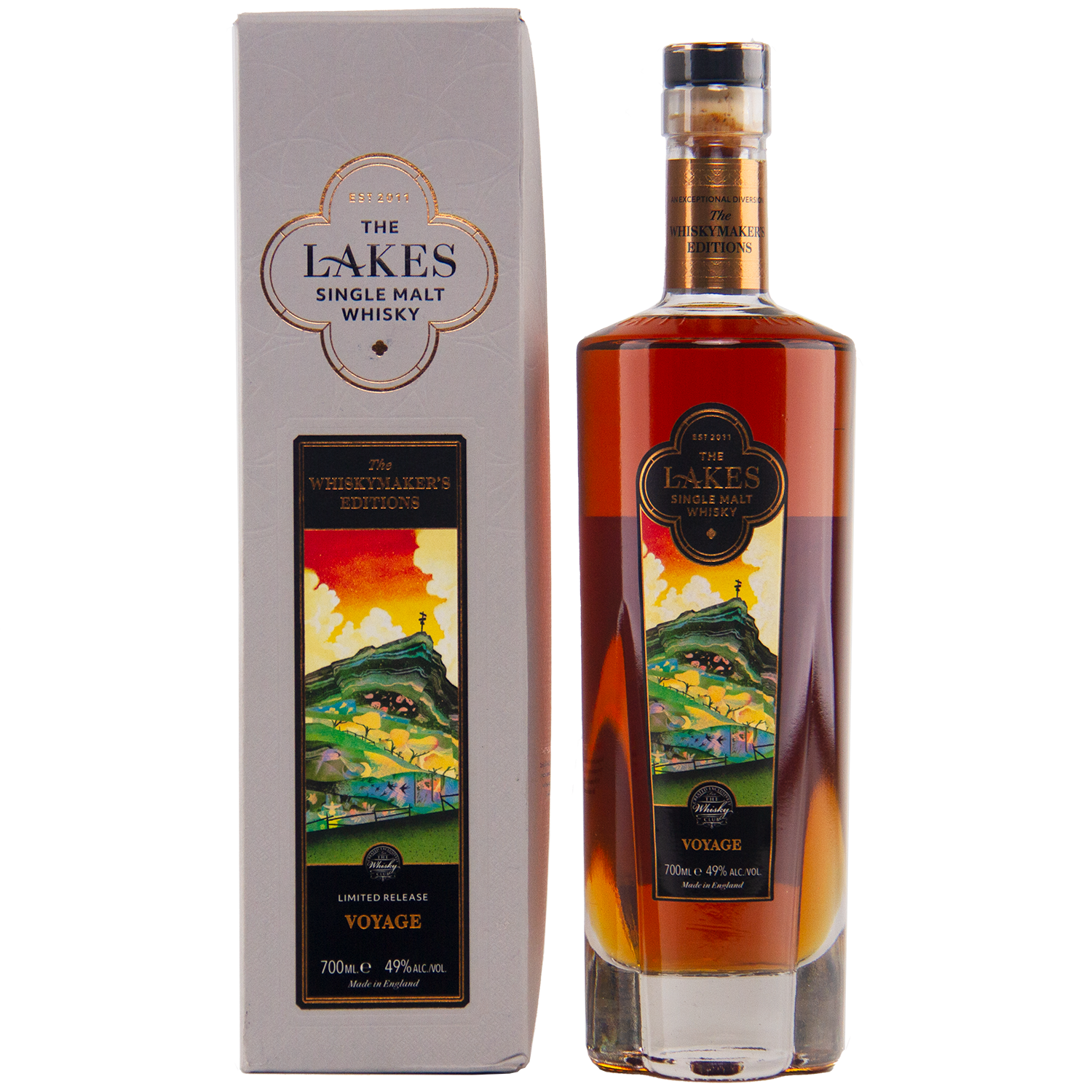 A 700ml bottle of The Lakes Whiskymaker’s Editions: Voyage Single Malt Whisky (49% ABV) stands beside its colorful scenic box. This limited release from The Lakes Distillery features hills and water on its label.