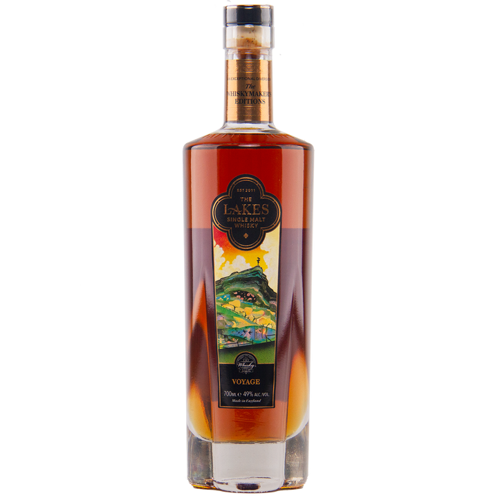 A tall bottle of The Lakes Whiskymaker’s Editions: Voyage Single Malt Whisky, with a colorful front label, holds dark amber spirit from The Lakes Distillery and is sealed with a cork top.