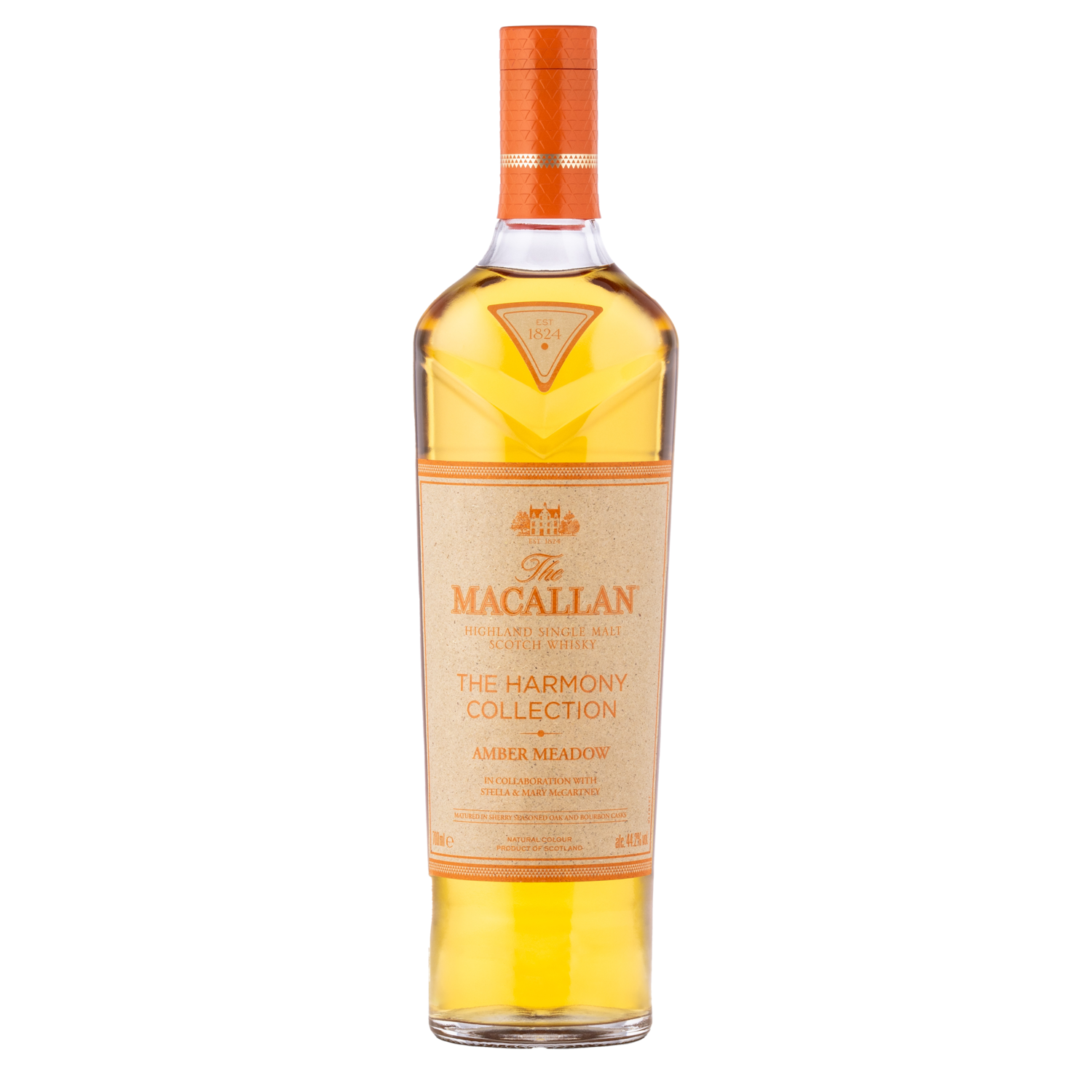 A bottle of The Macallan Harmony Collection Amber Meadow Single Malt Scotch Whisky with sustainable packaging, light amber liquid, and an orange cap and label on a plain white background.