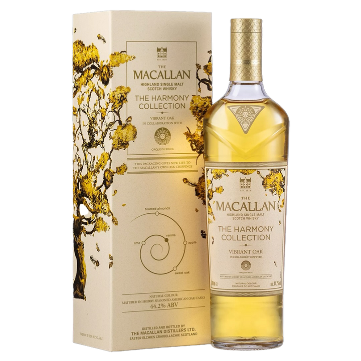 A bottle of The Macallan Harmony Collection Vibrant Oak Single Malt Scotch Whisky stands next to its cream and gold box decorated with tree branches, emphasizing oak sherry cask maturation on the label.