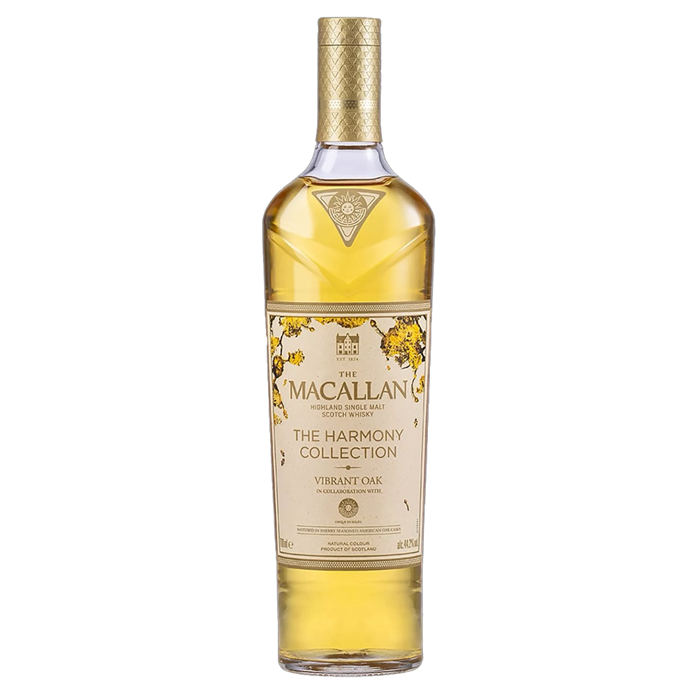 A limited edition bottle of The Macallan Harmony Collection Vibrant Oak Single Malt Scotch Whisky, featuring a gold and cream label, gold accents, and a patterned gold cap.