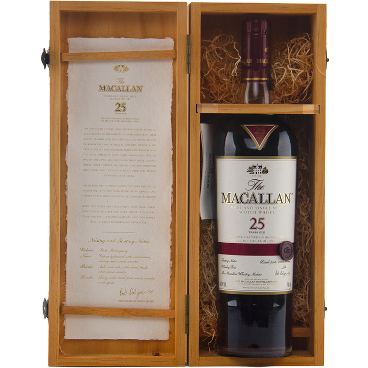 A bottle of The Macallan 25 Year Old Sherry Oak Single Malt Scotch Whisky (Pre-2018) rests in a wooden box with straw, featuring tasting notes on its rich sherry oak cask character inside the lid.