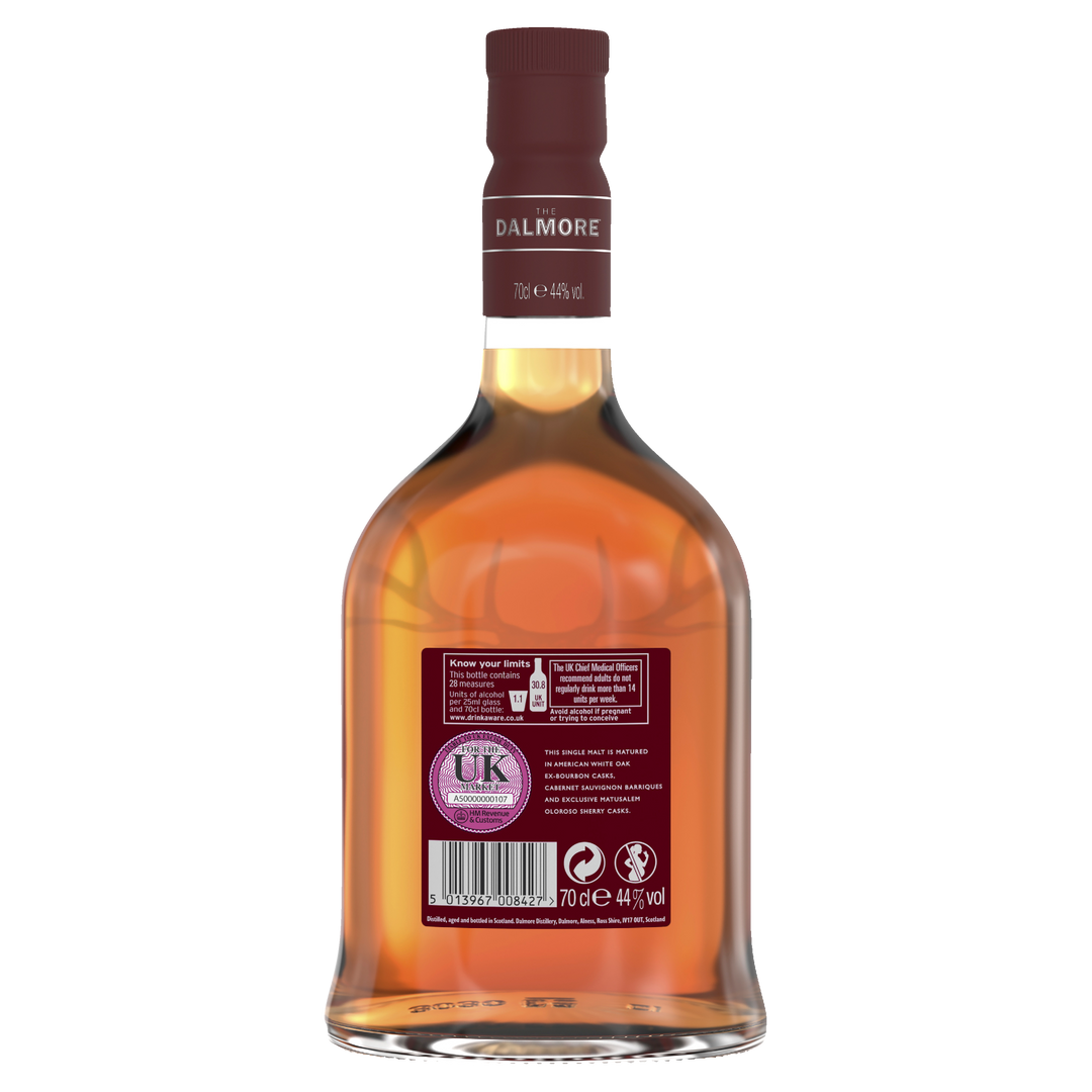 A bottle of The Dalmore Cigar Malt Reserve Single Malt Scotch Whisky shown from the back, featuring a maroon cap, UK alcohol warning labels, barcode, and product details. Its amber hue highlights its renowned cigar pairing qualities.
