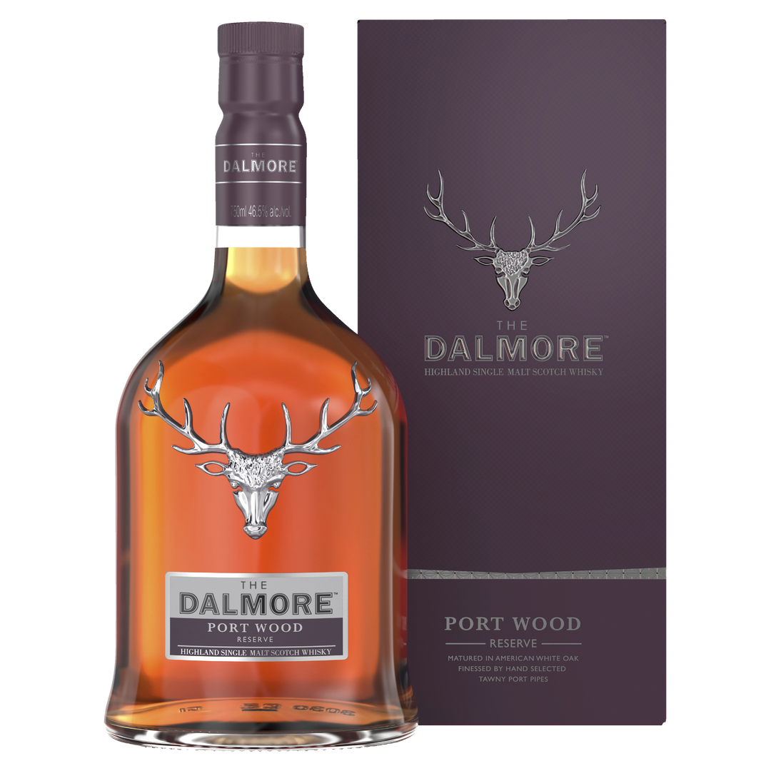 A bottle of The Dalmore Port Wood Reserve Single Malt Scotch Whisky stands next to its matching purple box, both adorned with a silver stag logo and white text. The rich amber whisky inside highlights its port cask influence.