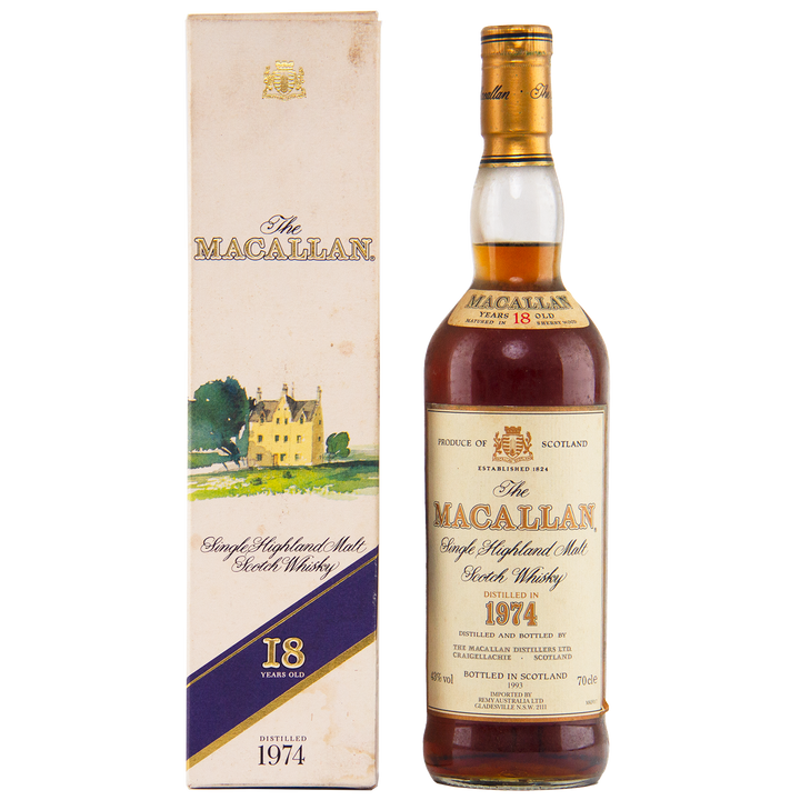 A bottle of The Macallan 1974 18 Year Old Sherry Single Malt Scotch Whisky stands beside its cream box, which displays a yellow house illustration and The Macallan branding.