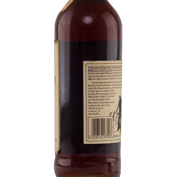 A close-up of the back label on a brown glass bottle of The Macallan 1974 18 Year Old Sherry Single Malt Scotch Whisky, showing maturation details, text, and a barcode. The label includes a small graphic at the bottom right and the side of the bottle is visible.
