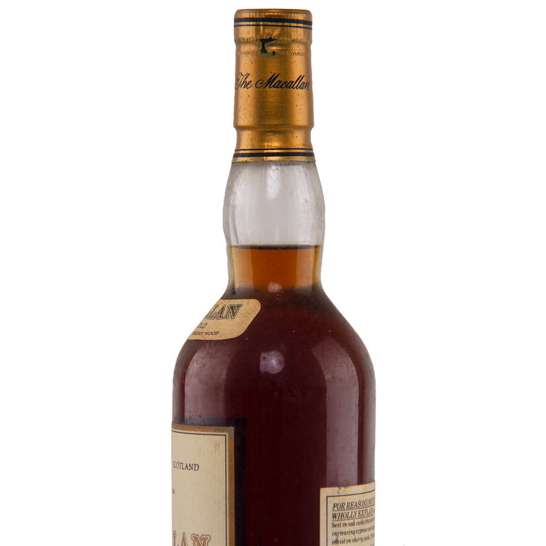 A close-up of the upper half of a dark glass bottle of The Macallan 1974 18 Year Old Sherry Single Malt Scotch Whisky, highlighting its amber liquid, gold cap, and labels—a rare collectible prized for sherry cask maturation.