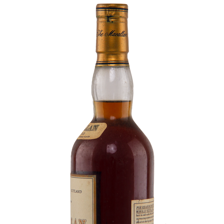 A close-up of the upper half of a dark glass bottle of The Macallan 1974 18 Year Old Sherry Single Malt Scotch Whisky, highlighting its amber liquid, gold cap, and labels—a rare collectible prized for sherry cask maturation.