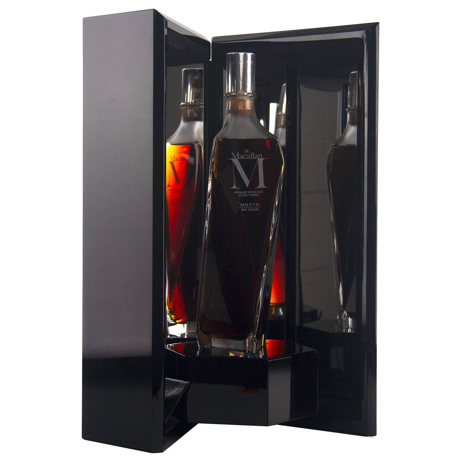 A dark, sleek display case reveals The Macallan M (2017 First Release) Single Malt Scotch Whisky, its clear angular bottle with a silver cap reflecting on glossy surfaces and showcasing its sherry oak maturation.