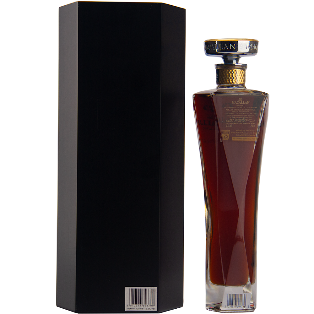 A tall, elegant bottle of The Macallan Oscuro Single Malt Scotch Whisky, matured in sherry-seasoned oak casks, stands next to a sleek black box—both shown from the back with barcode stickers—an exclusive travel retail release.