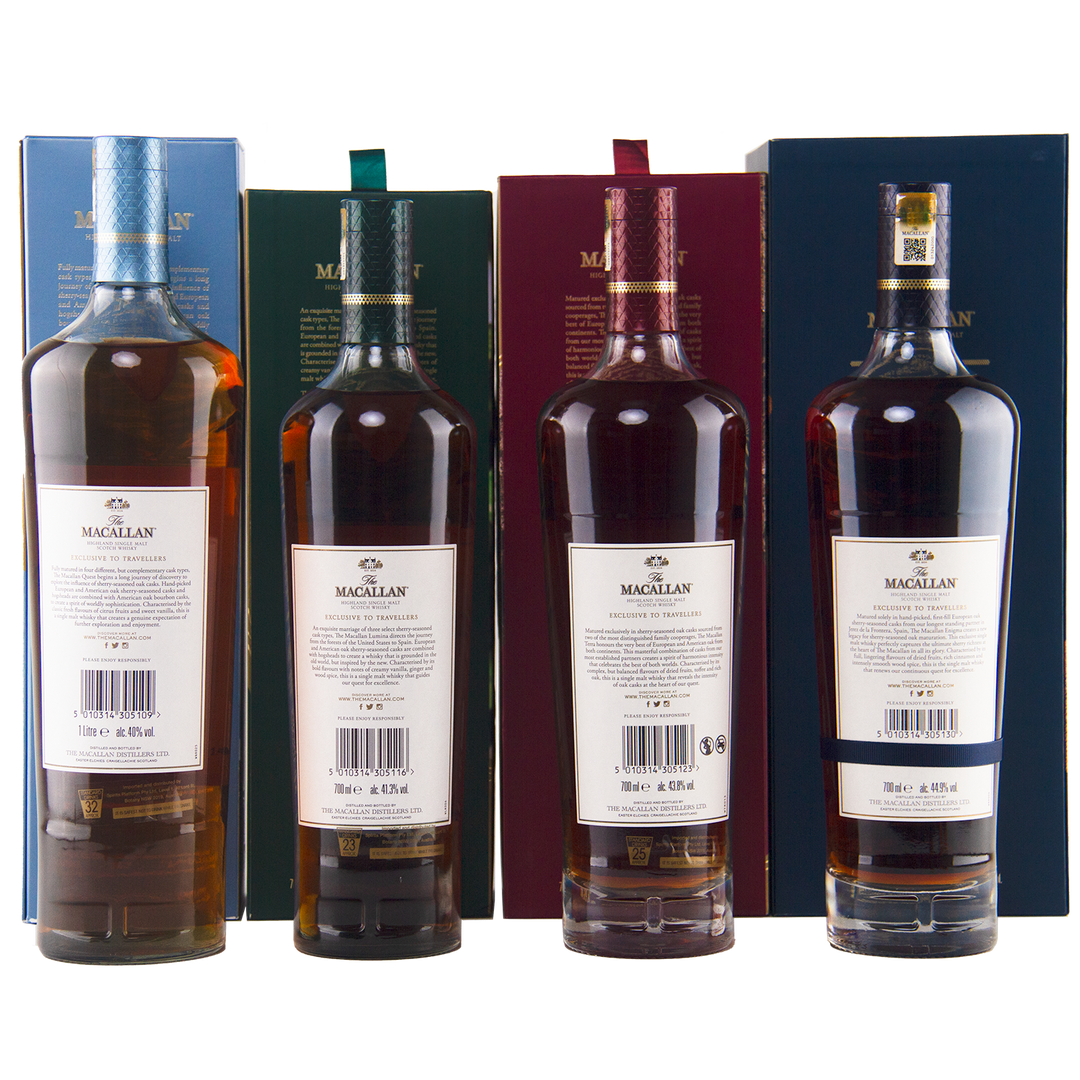 Four bottles of The Macallan Quest Complete Series Single Malt Scotch Whisky are lined up before their matching colored boxes—blue, green, red, and dark blue—with all back labels and barcodes visible.