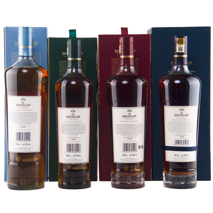 Four bottles of The Macallan Quest Complete Series Single Malt Scotch Whisky are lined up before their matching colored boxes—blue, green, red, and dark blue—with all back labels and barcodes visible.