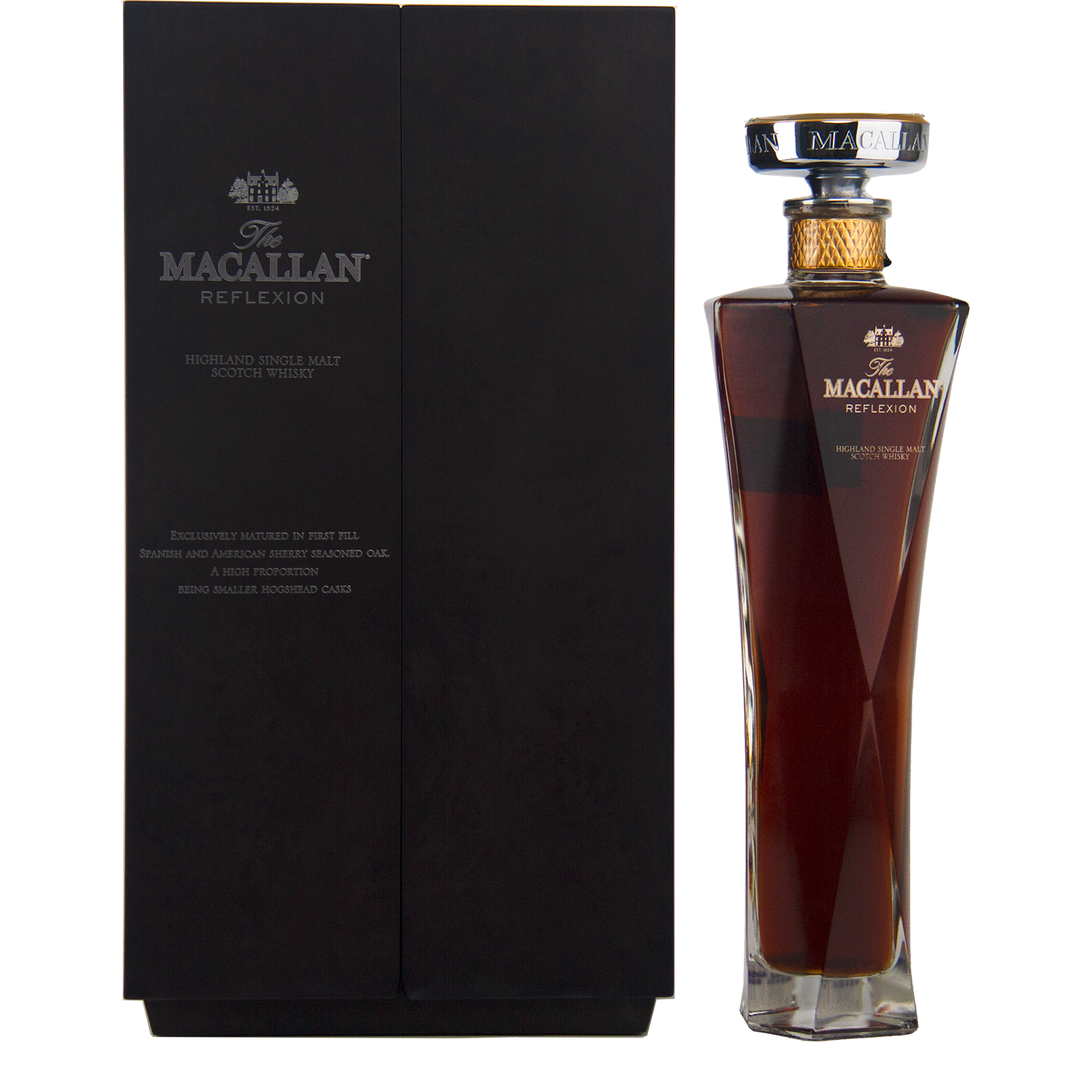 A tall, elegant bottle of The Macallan Reflexion Single Malt Scotch Whisky stands beside its sleek black box, both adorned with gold and white labels—a tribute to sherry cask maturation.