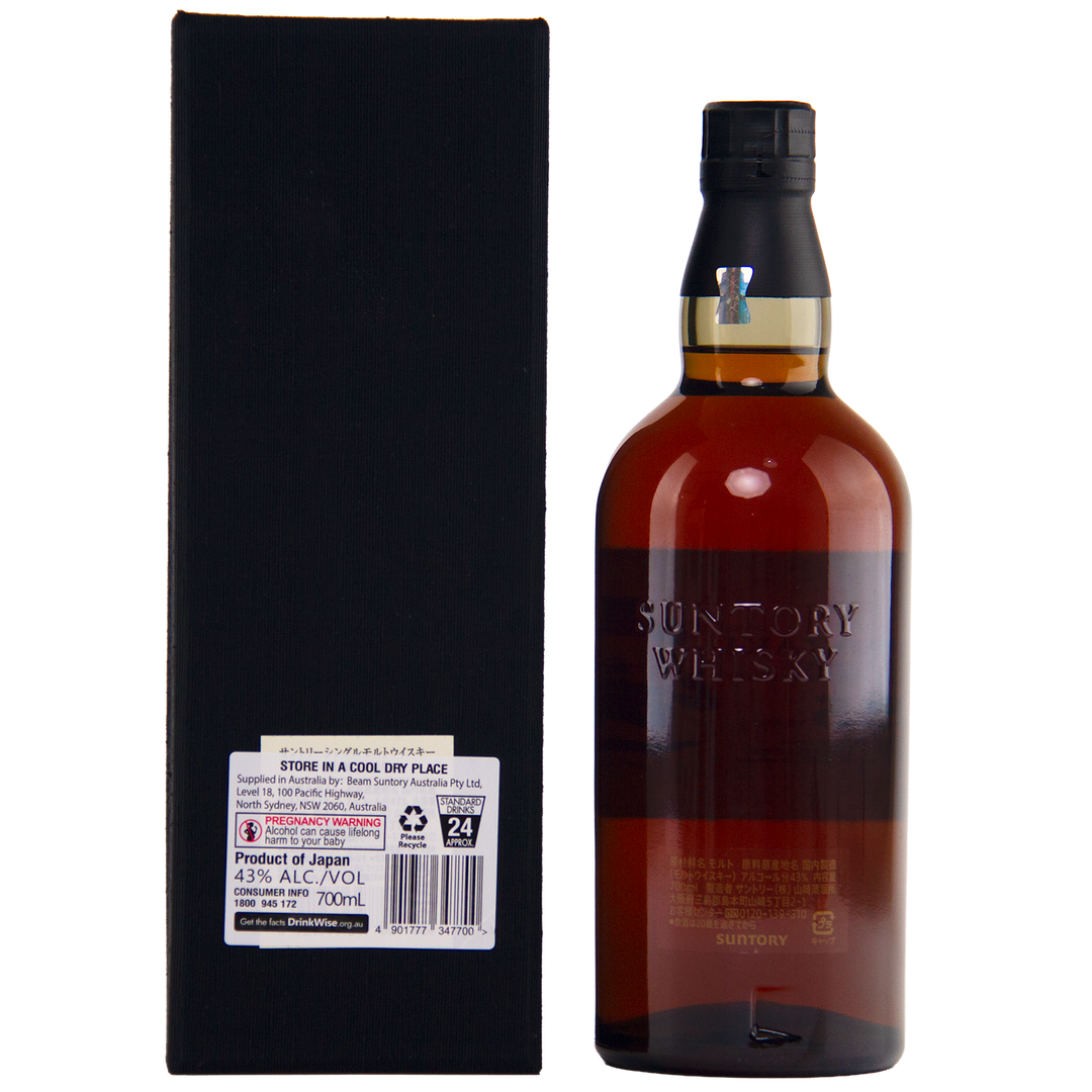 A bottle of Yamazaki 25 Year Old Japanese Single Malt Whisky stands beside its black box. The amber liquid fills an embossed bottle, while the box features a label detailing product info and its Mizunara oak cask influence.