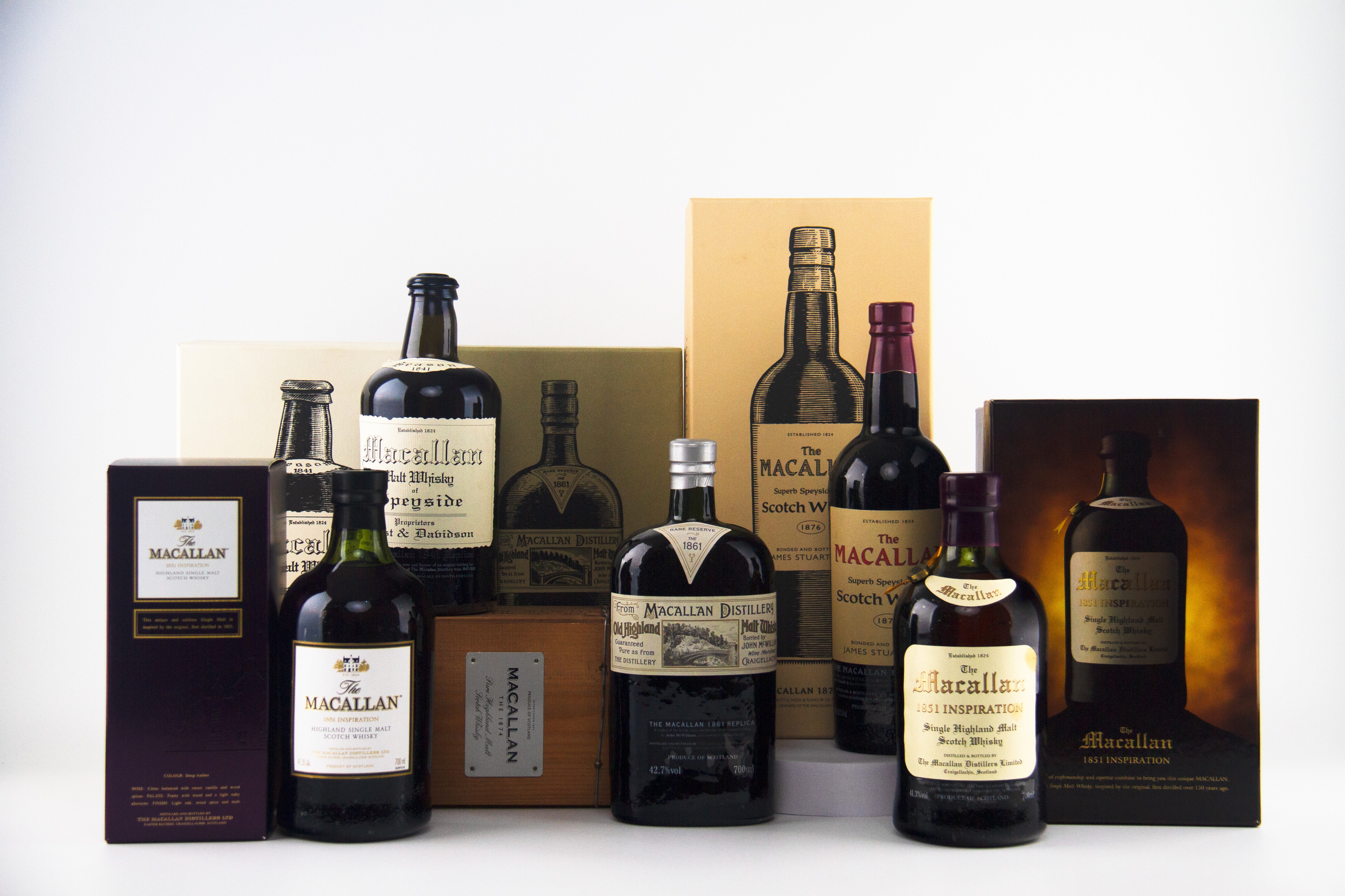 Collection of Macallan whiskey bottles and packaging on a white background