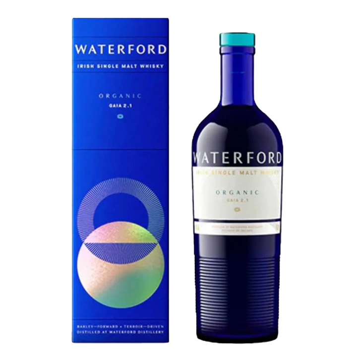 A blue bottle of Waterford Organic Gaia: Edition 2.1 Single Malt Whisky, made from organic Irish barley, stands beside its matching blue cylinder box adorned with colorful geometric patterns and organic-inspired text.