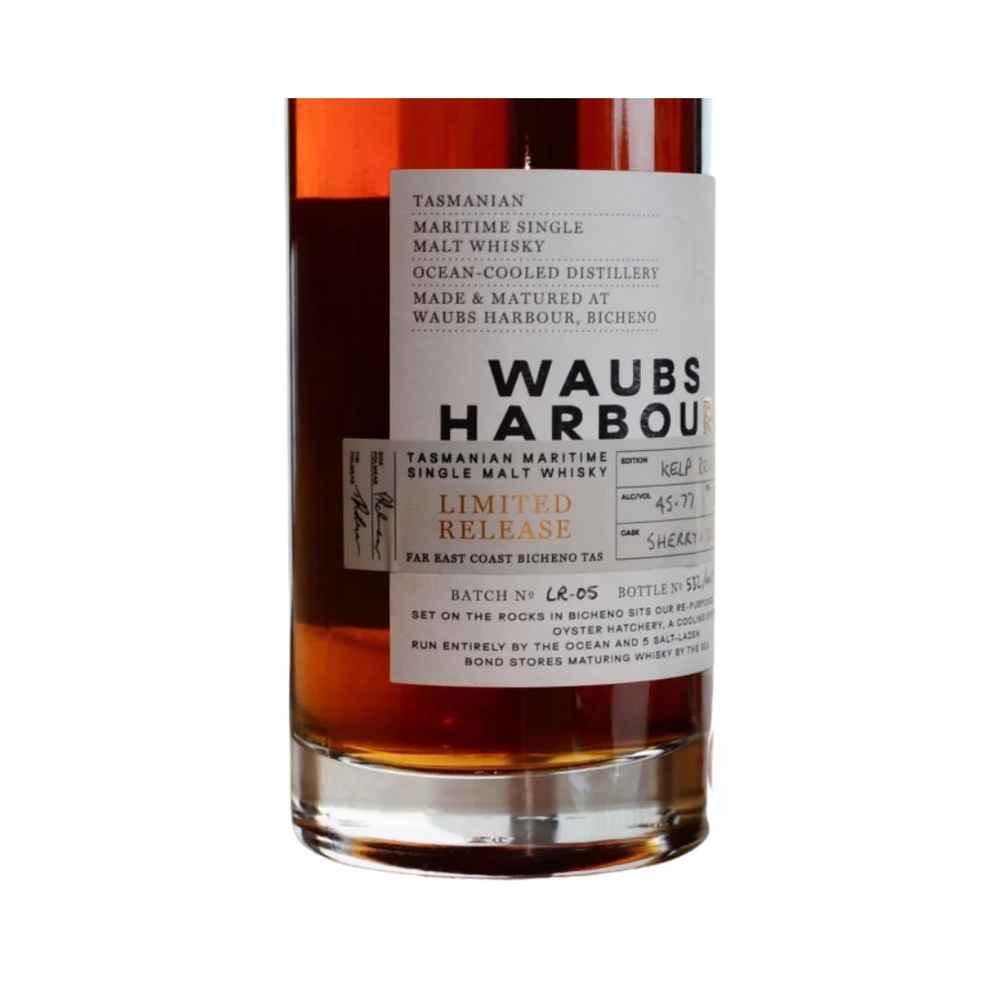 A bottle of Waubs Harbour Tasmanian Maritime Single Malt Whisky, Limited Release, showing the amber liquid and a white label with black text on a white background.