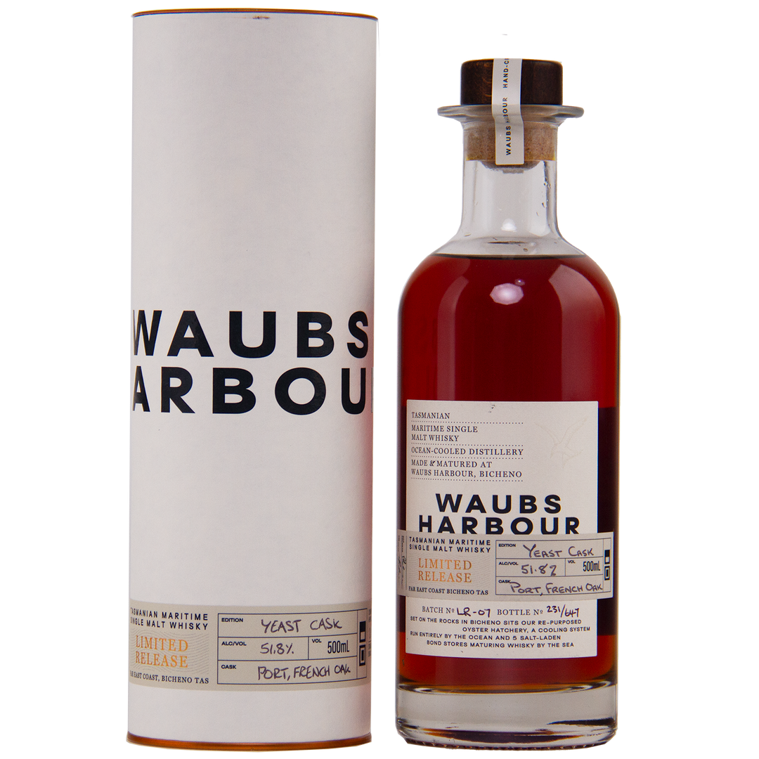 A bottle of Waubs Harbour Yeast Cask Single Malt Australian Whisky stands beside its white cylindrical case. The label notes Limited Release and Port, French Oak casks, highlighting this rich amber, limited-edition Australian whisky.