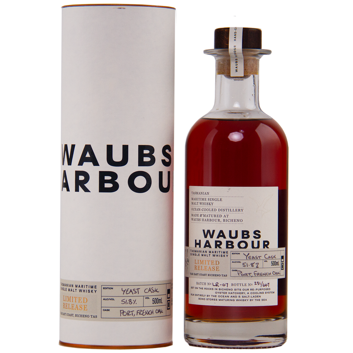 A bottle of Waubs Harbour Yeast Cask Single Malt Australian Whisky stands beside its white cylindrical case. The label notes Limited Release and Port, French Oak casks, highlighting this rich amber, limited-edition Australian whisky.