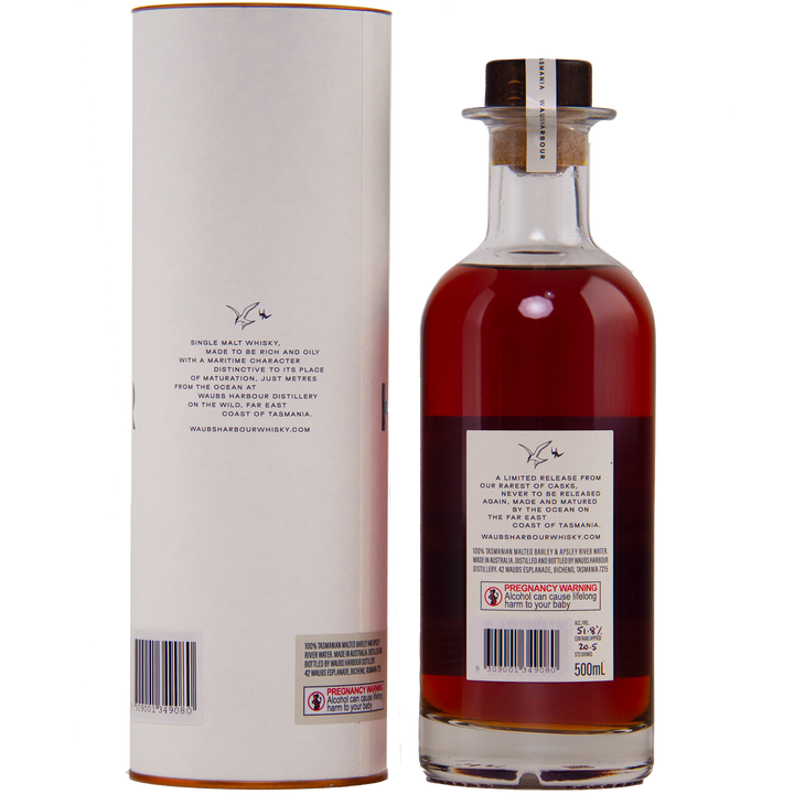 A 500ml bottle of Waubs Harbour Yeast Cask Single Malt Australian Whisky, rich amber in color with a clear glass stopper, stands beside its cylindrical packaging. Both feature labels and a signature logo. Limited-edition Australian whisky.