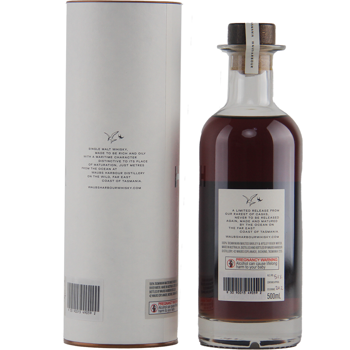 A bottle of Waubs Harbour PX Sherry Cask Single Malt Australian Whisky with a wax-sealed cork stands next to its cylindrical white box. Both labels detail the whisky and display barcodes near the bottom.