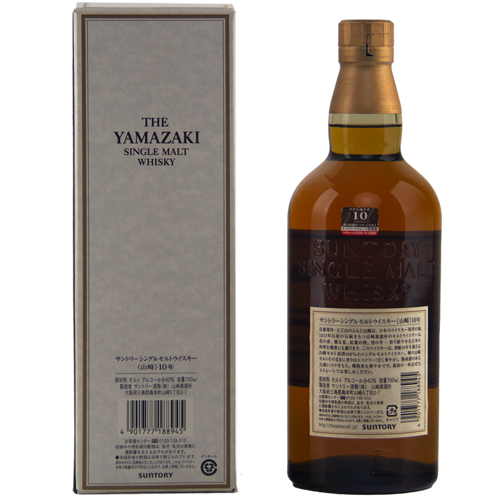 A bottle of Yamazaki 10 Year Old Japanese Single Malt Whisky, released for Suntory’s 100th Anniversary, stands next to its box. It has a brown cap and a beige label with English and Japanese text.