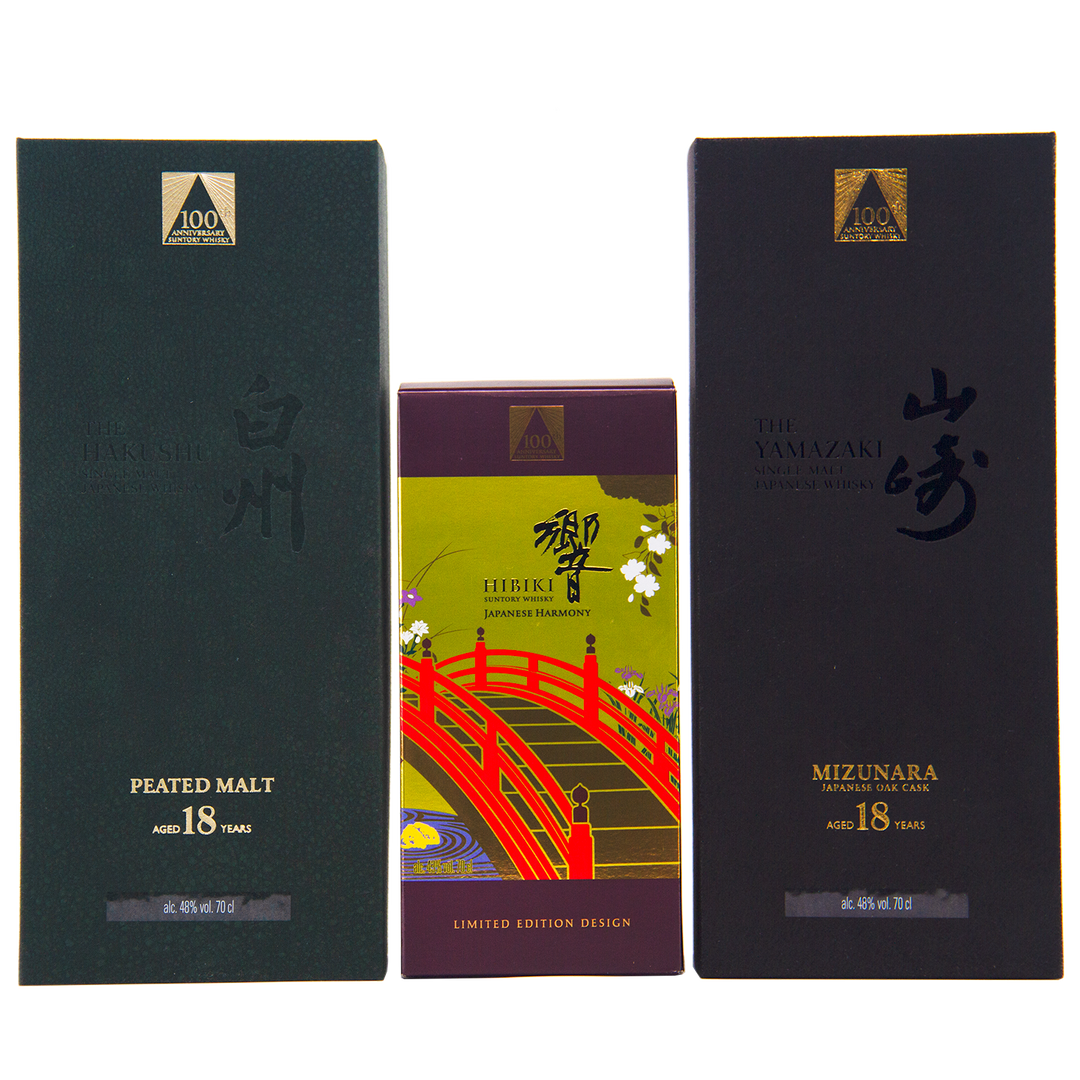 Three Japanese whisky boxes are displayed: Hakushu 18 (green box), Hibiki 100th Anniversary Set (colorful box with a red bridge), and Yamazaki 18—a highlight of the anniversary set.