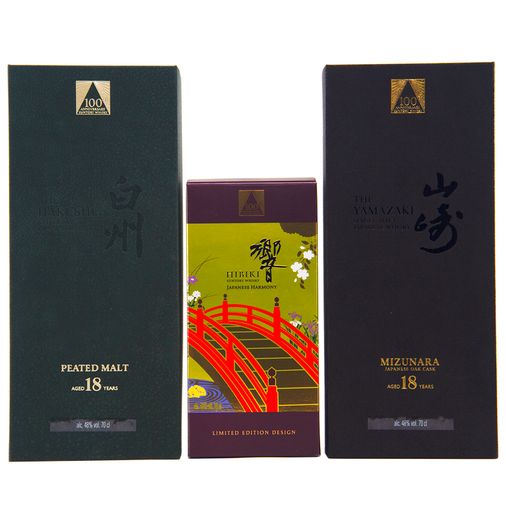 Three Japanese whisky boxes are displayed: Hakushu 18 (green box), Hibiki 100th Anniversary Set (colorful box with a red bridge), and Yamazaki 18—a highlight of the anniversary set.