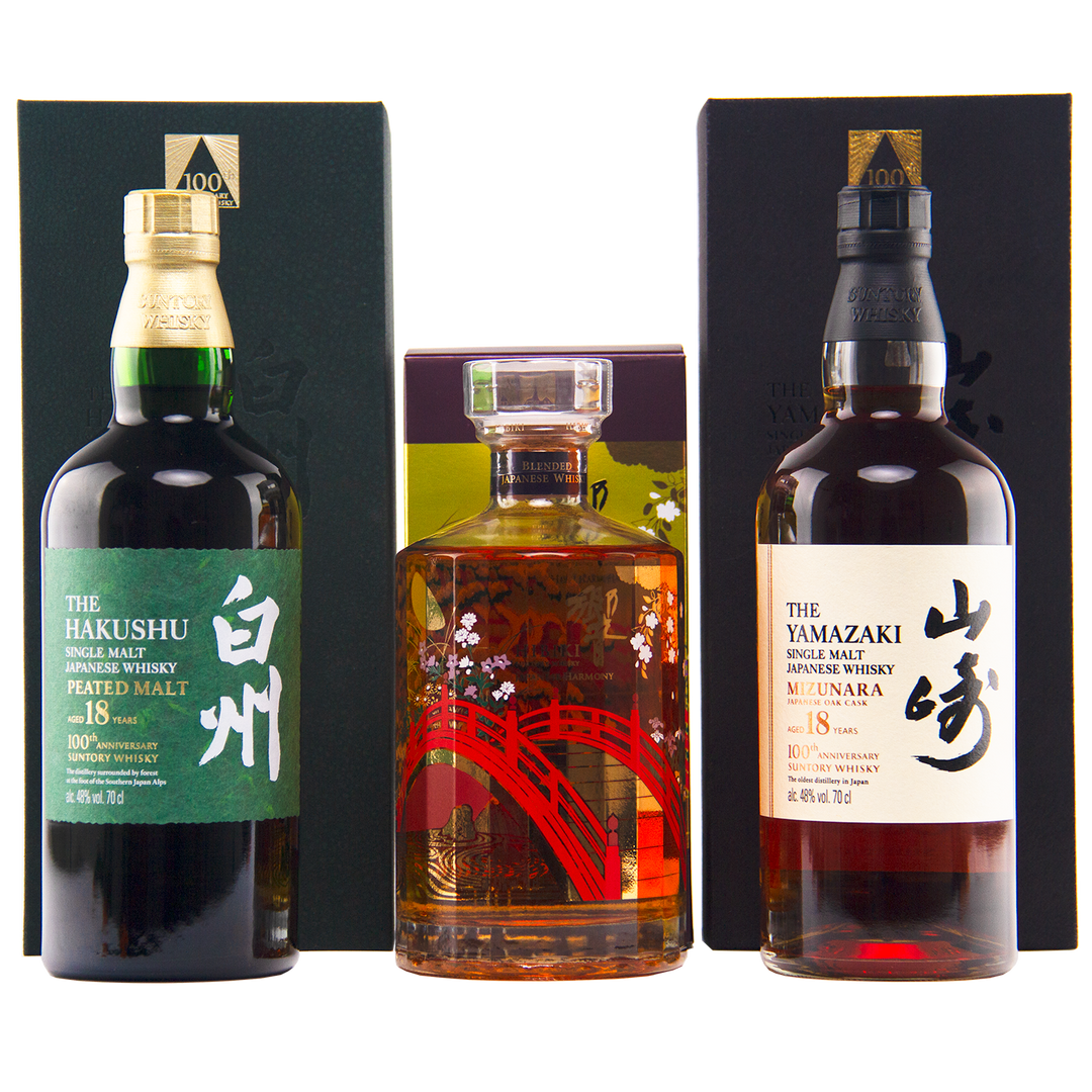 Three bottles—Yamazaki 18, Hakushu 18, and the Hibiki 100th Anniversary Set—are displayed in front of their boxes.