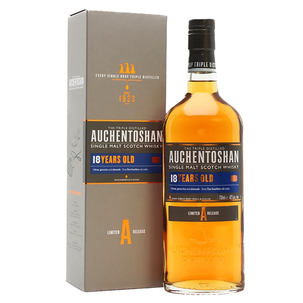A bottle of Auchentoshan 18 Year Old Single Malt Scotch Whisky is placed beside its grey and orange box, with labels highlighting triple distillation, limited release, and a 700 ml size.
