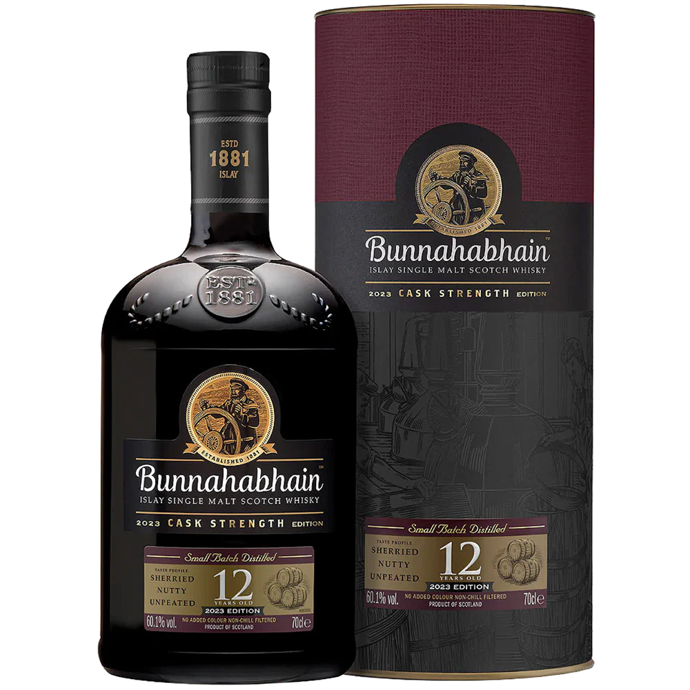 A bottle of Bunnahabhain 12 Year Old Cask Strength Single Malt Scotch Whisky stands before its cylindrical box, both featuring gold and maroon labels with the distillery’s logo and whisky details.