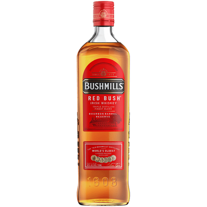 A bottle of Bushmills Red Bush Irish Whiskey, featuring a red label, gold lettering, and a red cap with "Bourbon Barrel Reserve" and "1608" embossed on the glass—this smooth blend is aged in bourbon casks.