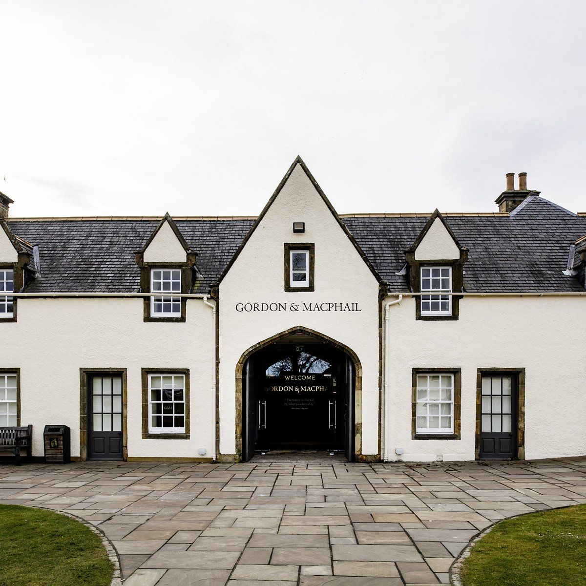 White building with 'Gordon & MacPhail' sign on a cloudy day